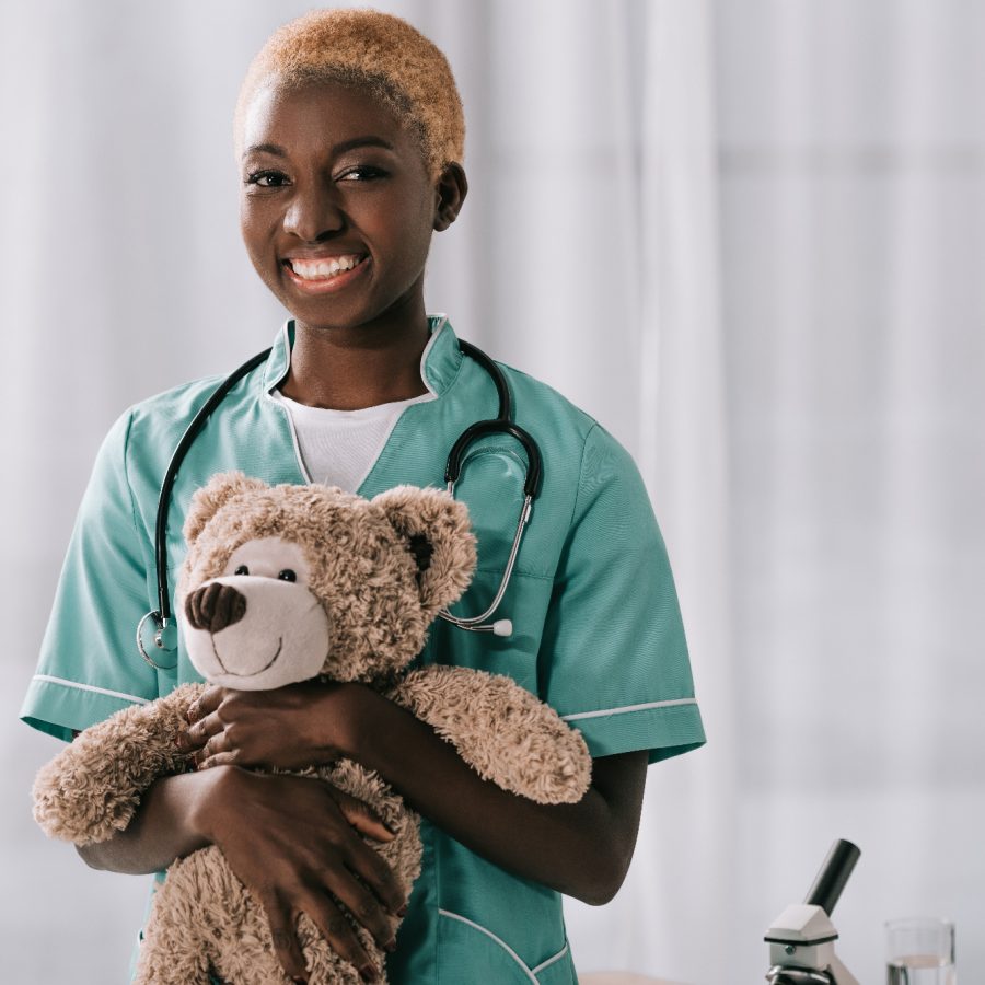 cheerful-african-american-nurse-holding-teddy-bear-2023-11-27-04-51-00-utc